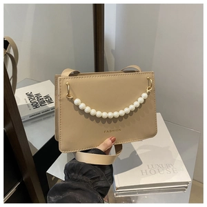 Detail of beige rectangular handbag with pearl chain and fashion letter engraving