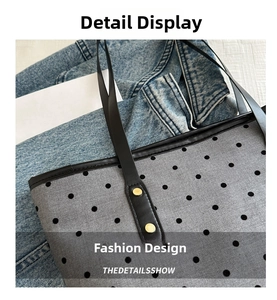 Détail du cabas gris à pois avec anses en cuir et rivets métalliques dorés