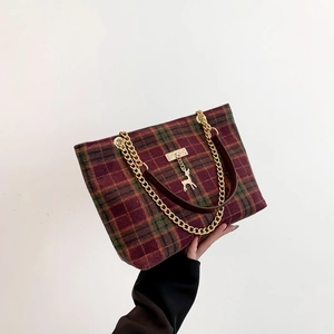 Winter plaid tote bag with red and green wool patterns and gold deer pendant charm
