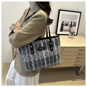 Detail of the high-density plaid canvas tote bag with a leather fashion patch