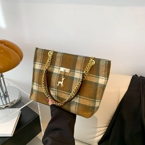 Retro plaid tote bag with gold chain strap and deer charm shown in a hand-held view