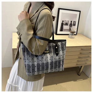 Detail of checkered tote bag featuring woven texture, black dots, and fashion label detail