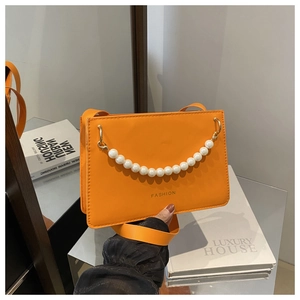 Detail of orange PU leather crossbody bag with pearl chain and Fashion logo text