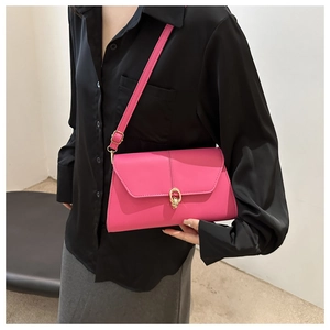 Detail of rose pink shoulder bag with golden double ring buckle and leather texture
