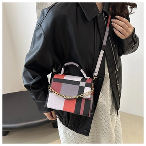 Detail of color-block plaid crossbody bag featuring a stylish gold chain and top handle
