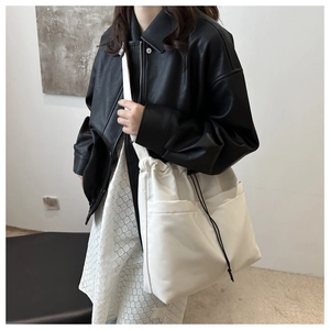 Detailed view of white nylon bucket bag with drawstring closure and side pockets
