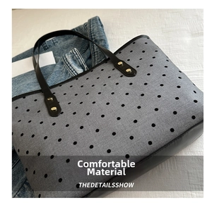 Gros plan d'un sac cabas gris imprimé étoiles avec anses en cuir sur veste en jean