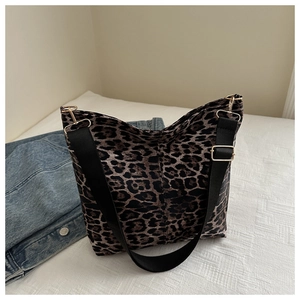 Detail of leopard print canvas tote bag with wide nylon strap and gold metal buckle