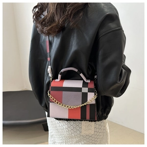 Modern geometric plaid crossbody bag shown on a model with gold chain accent detail