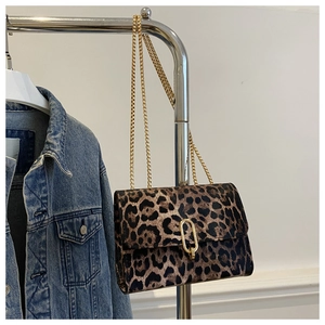 Detail of leopard print crossbody bag with golden U-shaped lock and chain strap