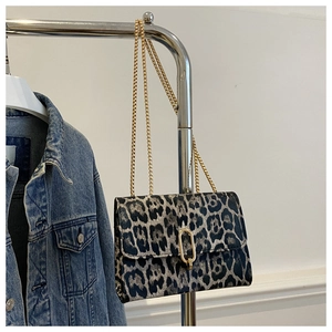 Detail of leopard print crossbody bag with gold chain strap and U-shaped metal lock