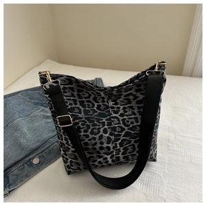 Detailed shot of leopard print tote bag with black wide strap and golden hardware