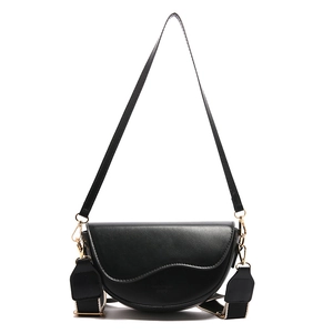Black saddle bag with wide striped strap and golden hardware in a 2024 vintage style