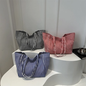 Trois grands sacs cabas en toile rayée en noir, rouge et bleu pour un usage quotidien