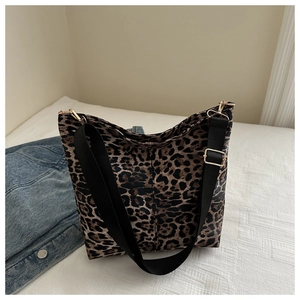 Close-up of leopard print canvas tote bag featuring adjustable black strap and gold buckle