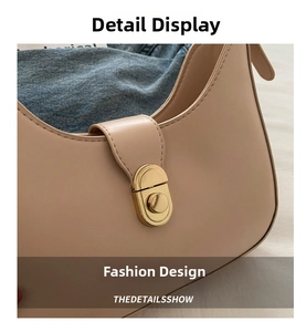 Detailed close-up of beige crescent bag featuring a vintage gold oval twist lock