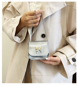 Detail view of mini silver metallic bag with butterfly buckle and chain strap