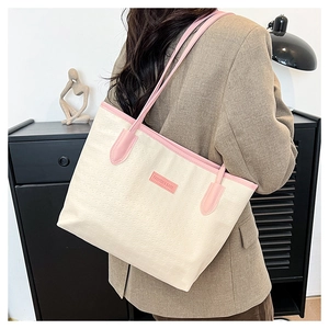 Detail of contrast pink piping and star-embossed texture on a chic beige tote bag