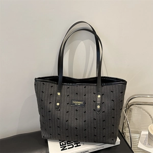 Large grey striped tote bag with bow embroidery and black leather straps for daily commute