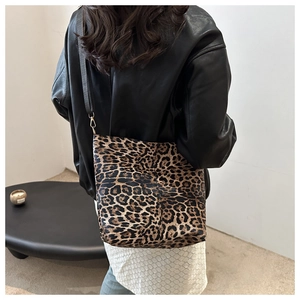 Detail of leopard print tote bag featuring gold hardware and a black shoulder strap
