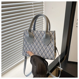 Détail du motif géométrique 3D bleu sur un sac carré compact porté en bandoulière