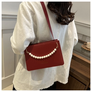 Deep red square shoulder bag with pearl handle and golden fashion lettering detail
