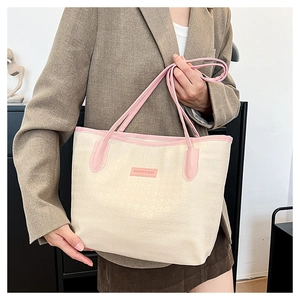 Detail of star textured cream and pink tote bag showing premium fashion hardware