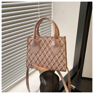 Gros plan sur le motif géométrique matelassé rose 3D et emblème de ce sac à main