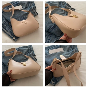 Detail view of beige hobo bag with golden twist-lock closure and adjustable strap