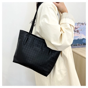 Detail of black houndstooth large tote bag featuring fashion metal logo and dual slim straps