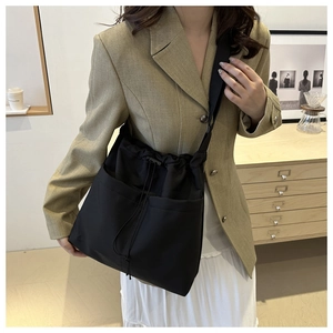 Large black drawstring bucket bag with dual pockets and adjustable strap for casual wear