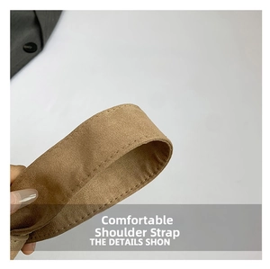 Détail d'une large bandoulière en daim marron avec coutures fines et texture mate douce