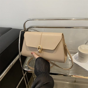 Minimalist beige crossbody bag with golden ring lock and textured leather finish