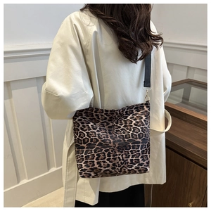 Close-up of leopard print canvas tote bag featuring durable black strap and golden hardware