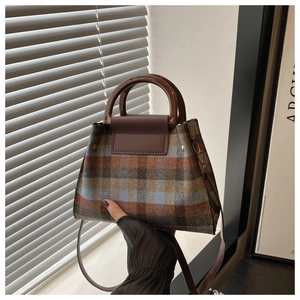 Detail of vintage plaid crossbody bag with brown handle and leather strap textures