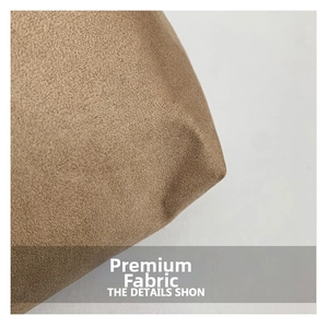 Gros plan sur la texture en daim fauve et les coutures du grand sac à main cabas