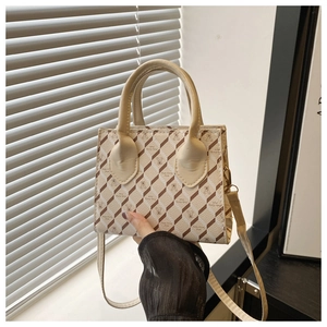 Détail du petit sac carré crème avec imprimé ours et poignée supérieure ronde
