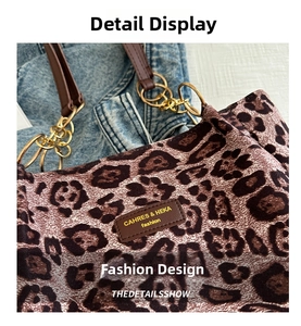 Detail of leopard print tote featuring gold chain hardware and brown leather handles