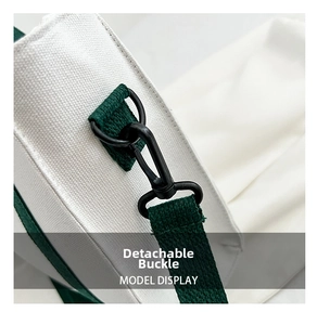 Gros plan de la boucle métallique amovible sur un sac en toile blanc avec sangle verte