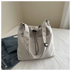 Detail of the drawstring closure and side pocket on this creamy white Oxford tote bag