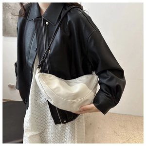 Minimalist white crescent shoulder bag shown on model with adjustable strap and contrast hardware