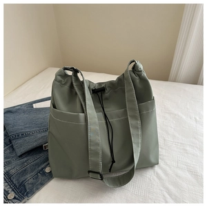 Detail of drawstring Oxford tote bag featuring contrast stitching and side pockets