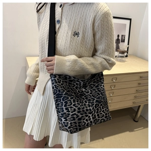 Leopard print canvas tote bag styled with white skirt and beige knit cardigan