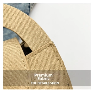 Detailed close-up of khaki woven fabric with precise stitching on a stylish shoulder bag