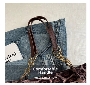 Detail of leopard print tote featuring brown leather straps and gold chain link accents