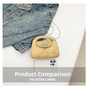 Close-up of yellow mini handbag with heart-shaped metal clasp and delicate chain detail