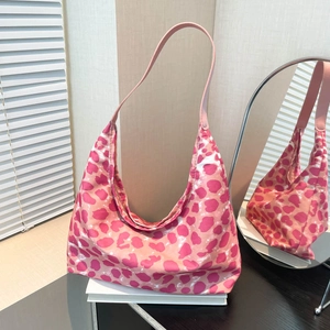 Pink leopard print canvas hobo bag with leather strap shown from a stylish side angle