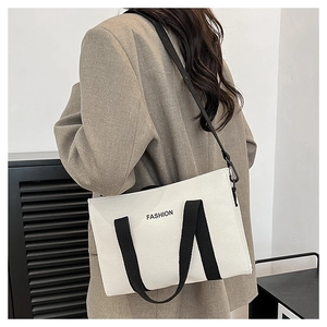 Détail du sac fourre-tout en toile avec anses contrastées noires et imprimé mode
