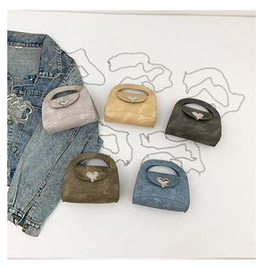 Detail of mini crossbody bags in five colors with heart buckles and silver metal chains