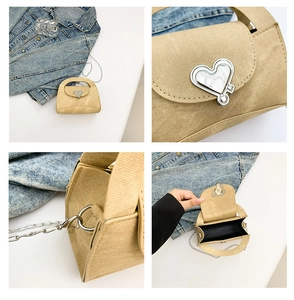 Detail view of khaki denim textured handbag with heart-shaped metal lock and chain strap